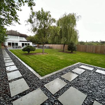 Modern backyard with stone pathways and green lawn.