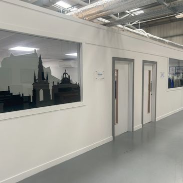 Indoor facility hallway with window and door decals.