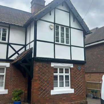 Traditional half-timbered house with brick and white paneling.