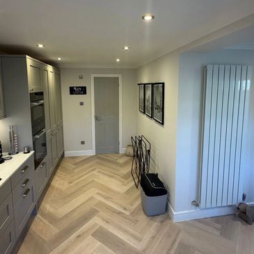 Modern kitchen with grey cabinets and herringbone floor.