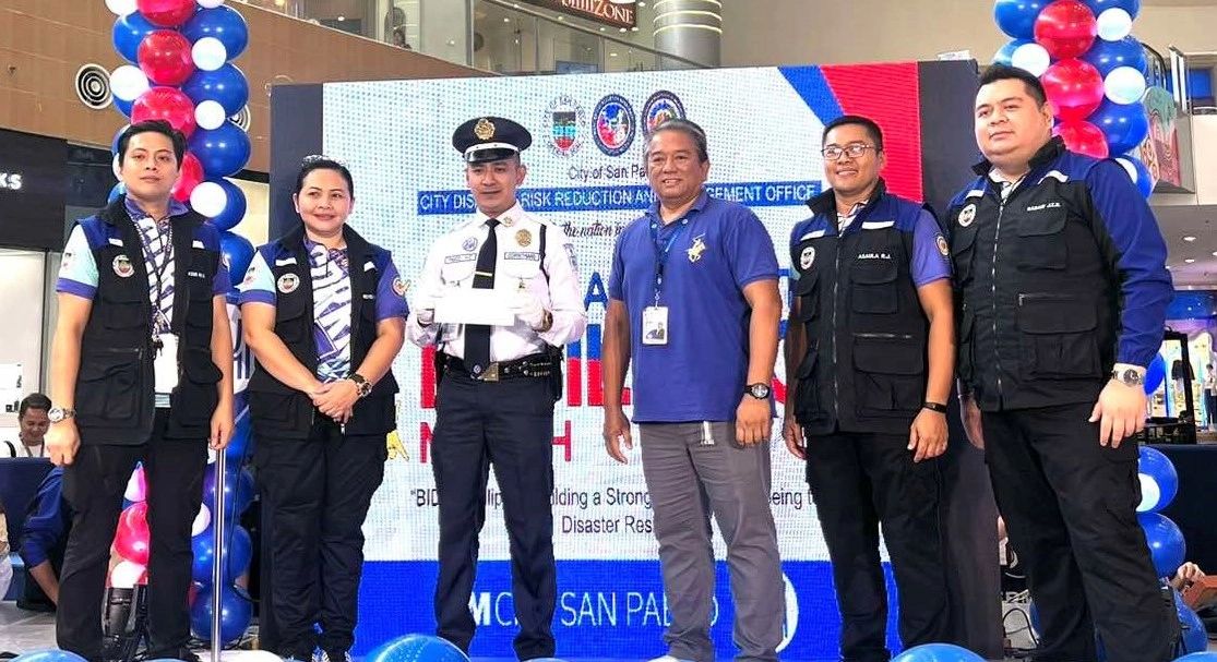 SG Hassan receives a plaque of recognition from the City Disaster Risk Reduction and Management Office officials:  (L to R) Ralph Kristian Eustaquio, Research and Planning Division Head, Vanessa T. Reyes, CGADH-I, CDRRMO , Rolly Asaula Administrative Division Head and John Edward Babani Administration and Training Division Head. With them is SM City San Pablo CRS Manager Ramon Domingo (3rd from right).