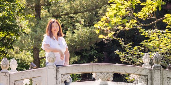 I Smiling woman  in a white dress on a bridge.