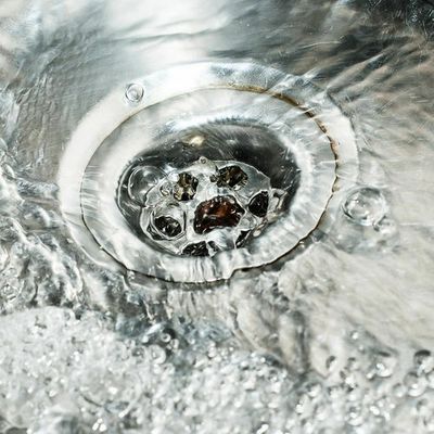 Photo of water running down a home sink draing