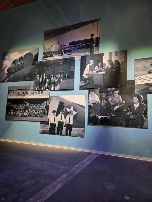 Historic black-and-white photos of Delta Air Lines displayed on a blue wall.