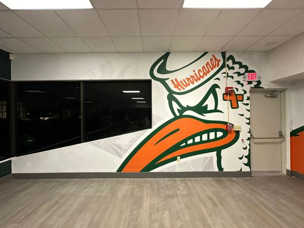 Large Hurricanes mascot mural on a wall with an exit door.