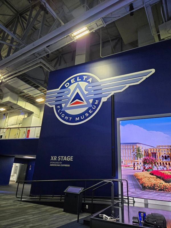 Interior of Delta Flight Museum's XR Stage with signage and a screen.