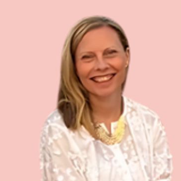Smiling woman in a white blouse with a gold necklace.