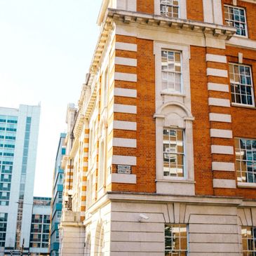 Classic brick building with white decorative accents in an urban setting.