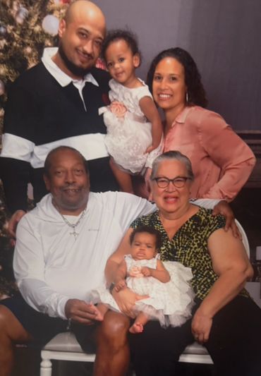 A joyful multi-generational family portrait with two babies and adults.