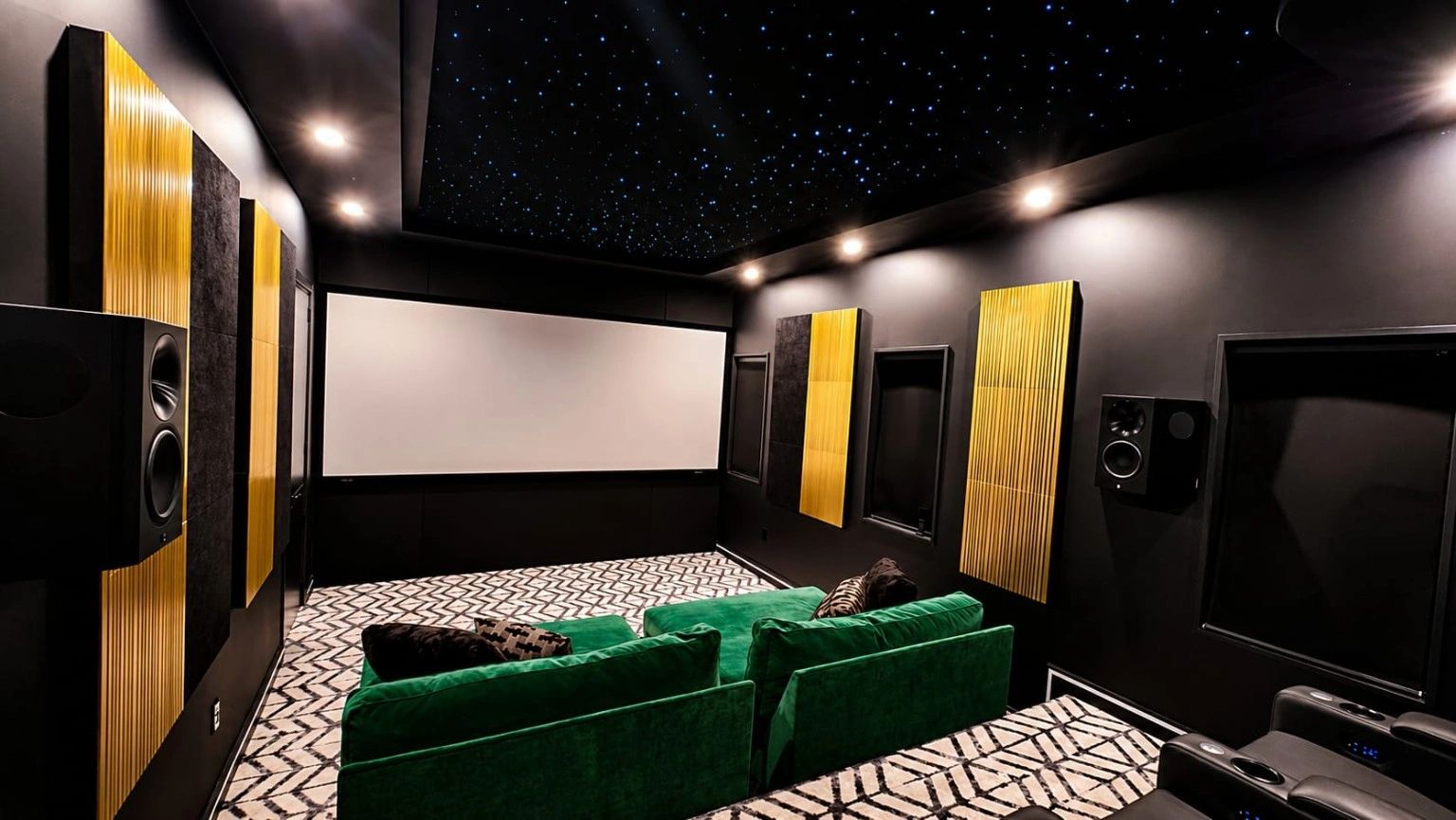 Modern home theater with green seats and starry ceiling.
