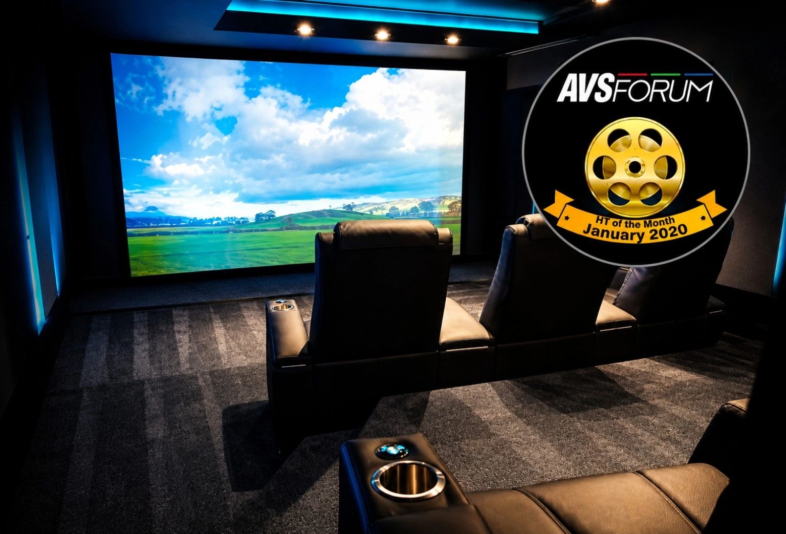 Modern home theater with luxurious black leather seats and a large screen.