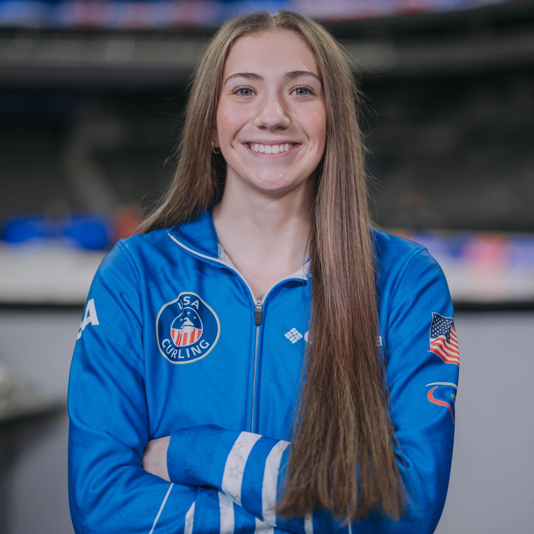 Young female athlete in USA Curling jacket smiling confidently.