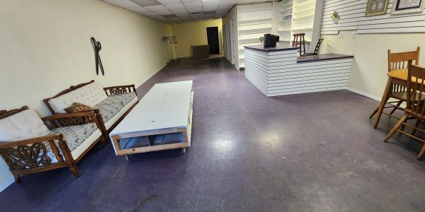 Bare room with wooden furniture and a white table.