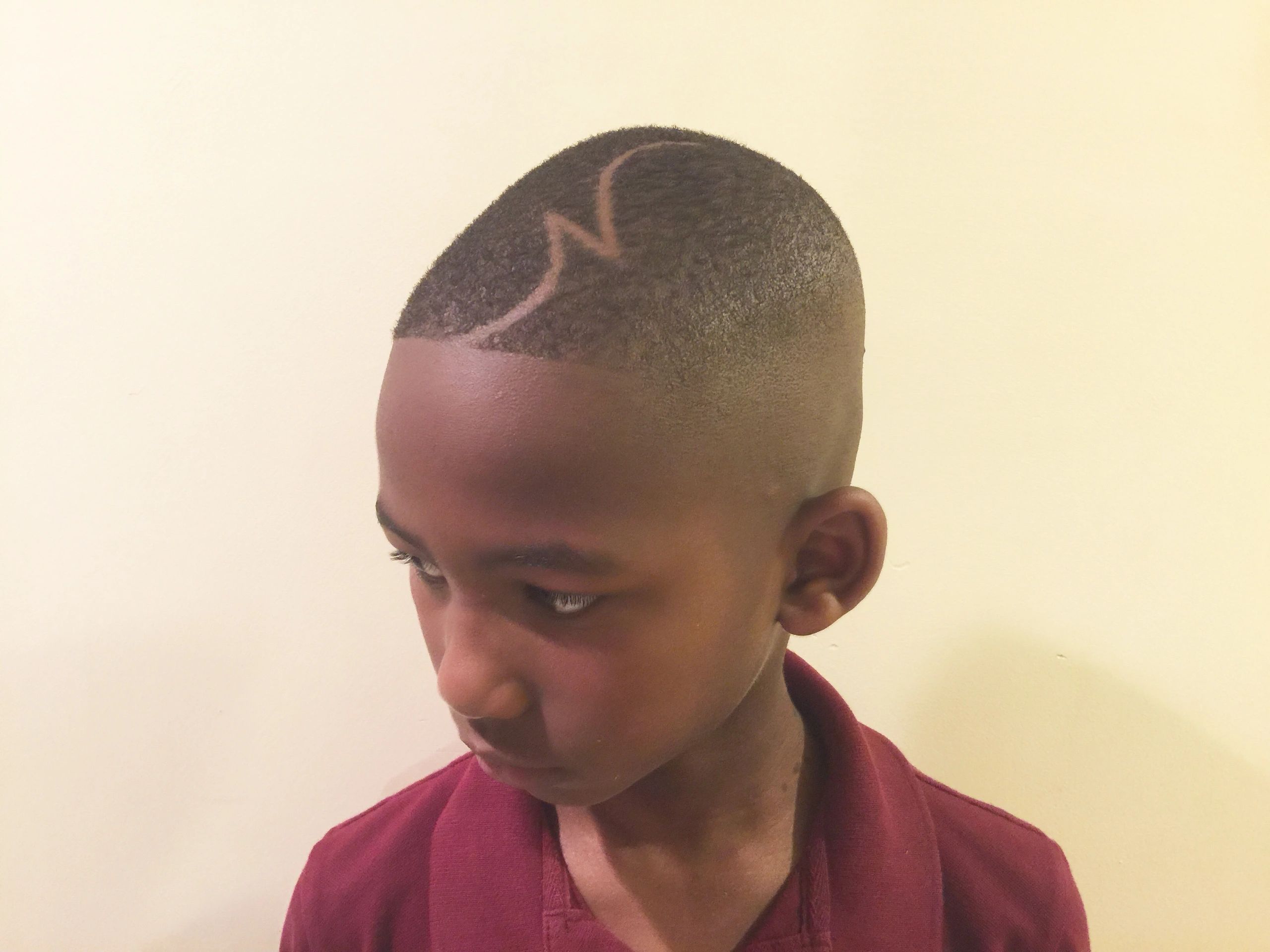 Boy with a zigzag hair design shaved into his short haircut.