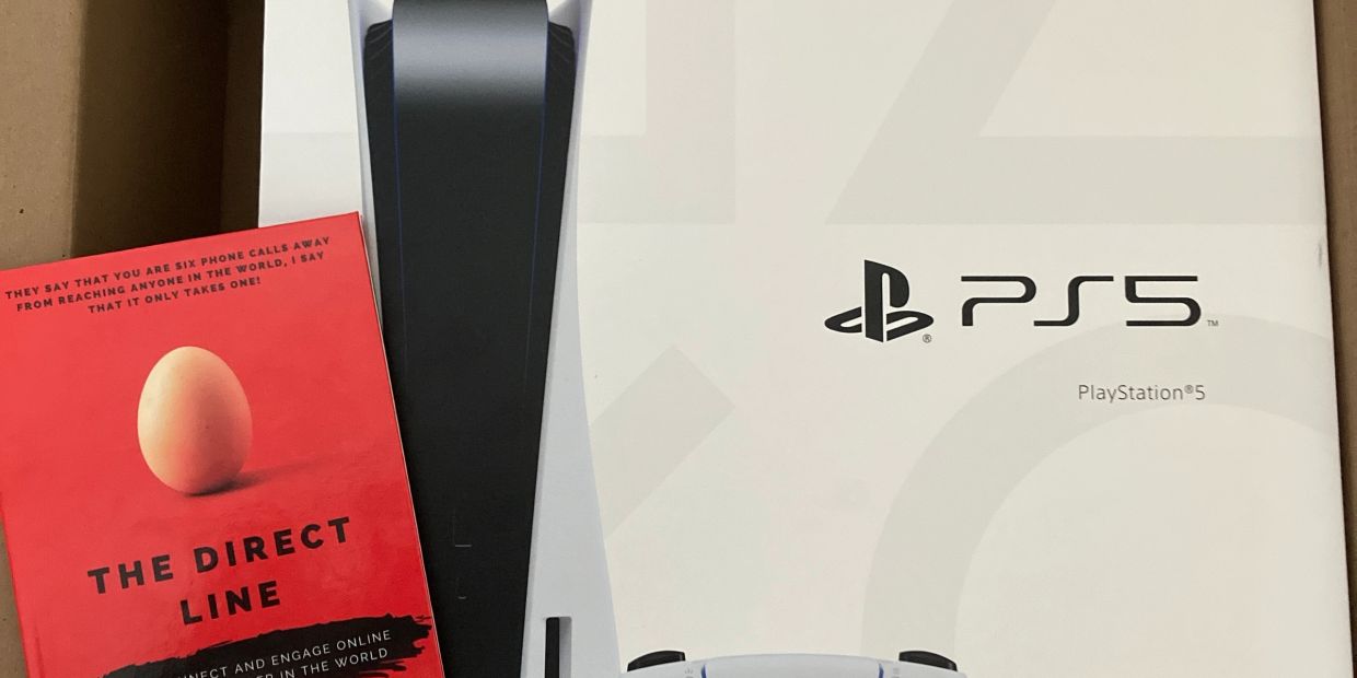 PS5 box partially covered by a red book titled The Direct Line.