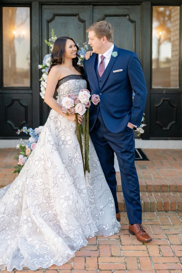 Real Bride wearing a black and champagne wedding dress standing with her groom