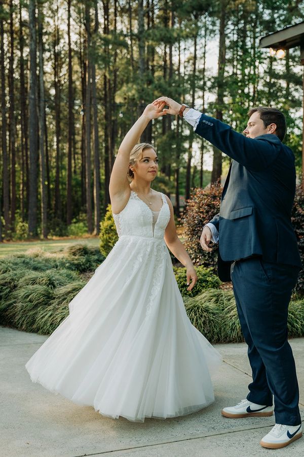 Real Bride Katia wearing a simple a-line wedding gown with a tulle skirt and an elegant plunge lace 