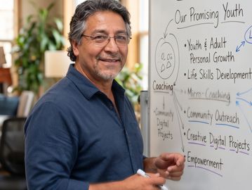 Man smiling while writing on a whiteboard.