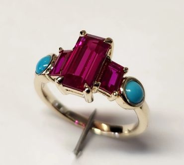 Elegant ring with red gemstones and turquoise accents.