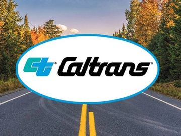 Caltrans logo over a scenic autumn road with trees.