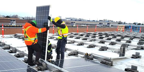 Solar panels being installed on a commerial building by profesional solar installers
