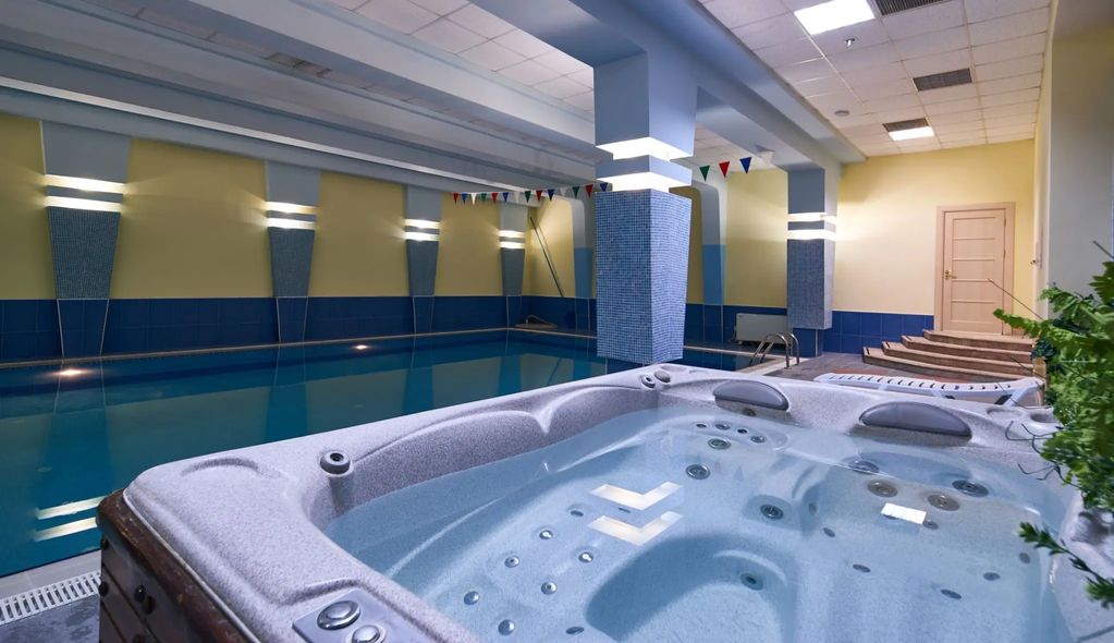 Indoor pool and jacuzzi area with calming lights.