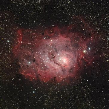 A vibrant pink and purple nebula surrounded by stars in deep space.