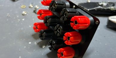 Close-up of red and black electrical connectors on a workbench.