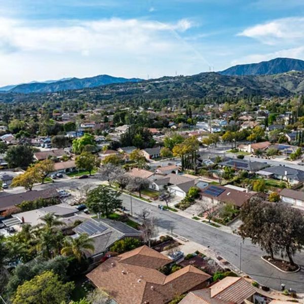A suburban neighborhood with houses and mountains in the background.