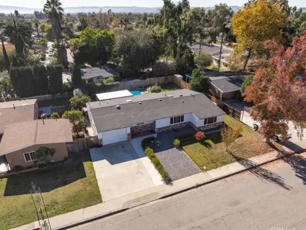 A single-story suburban house with a driveway and a fenced backyard.