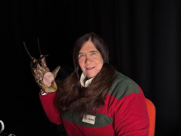 Person dressed as Freddy Krueger with signature glove and pigtails.