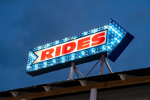 
The image shows a large, illuminated sign in the shape of an arrow pointing to the right