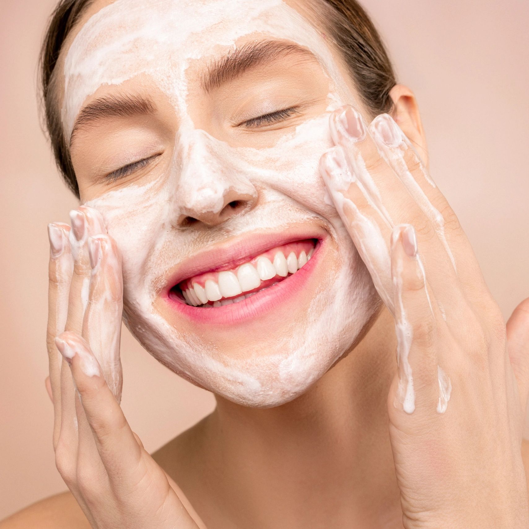 Woman smiling, enjoying a face cleansing