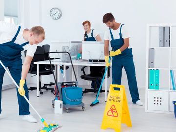 A janitorial team cleaning an office.