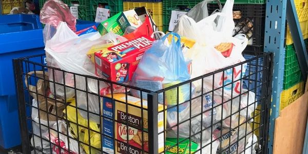 Overfilled shopping cart with groceries.