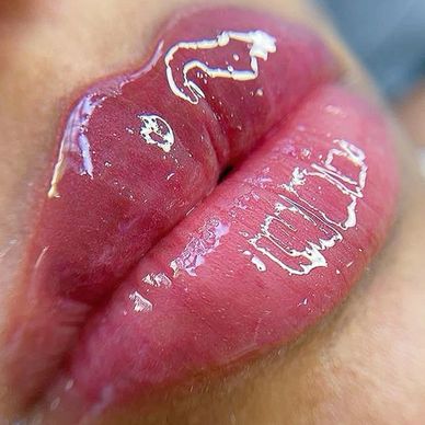 Close-up of glossy lips with shiny lip gloss.