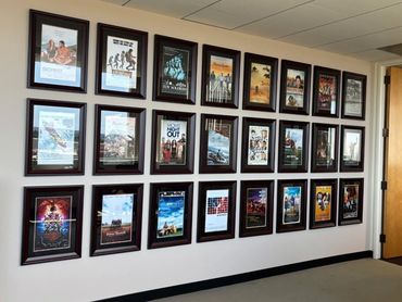 Wall of framed movie posters in an office hallway.