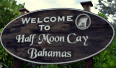 a welcome sign to half moon cay in a tropical setting