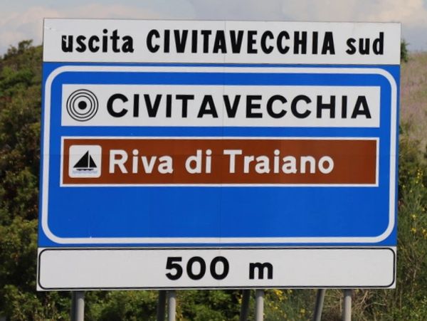 a blue and white sign sitting on the side of a road