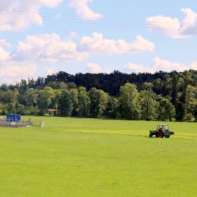 a green field with a tractor in the middle of it