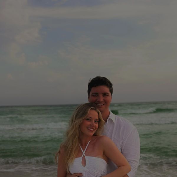 A happy couple embracing on a beach at sunset.