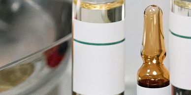 Close-up of medical ampoules and bottles on a reflective surface.