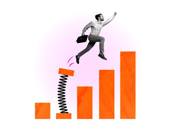 Businessman using a springboard to jump over a bar chart, symbolizing growth.