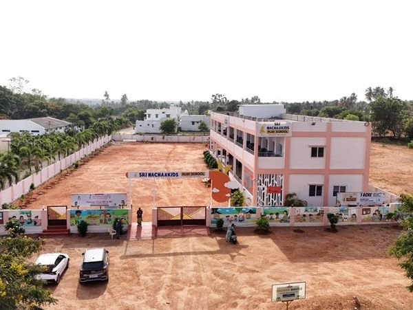 School building with open playground and cars parked.