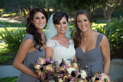 Professional wedding makeup artist applying lipstick for a bride.
