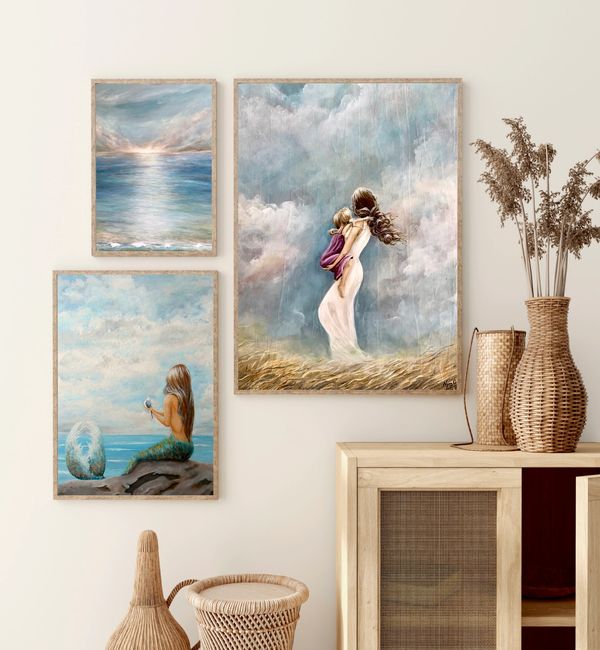Coastal paintings hanging on a wall.