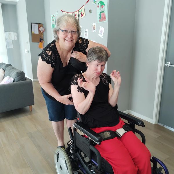 Image of Support and client in wheelchair smiling