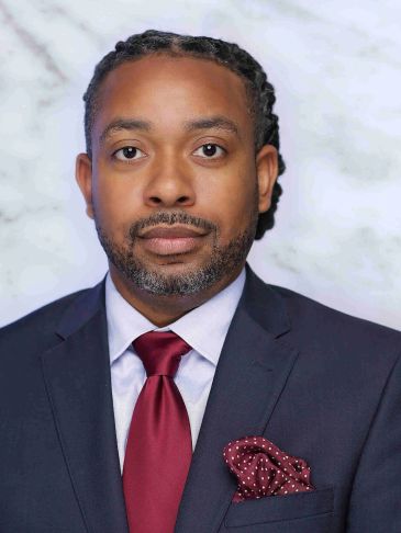Professional man in a suit with a maroon tie and pocket square.