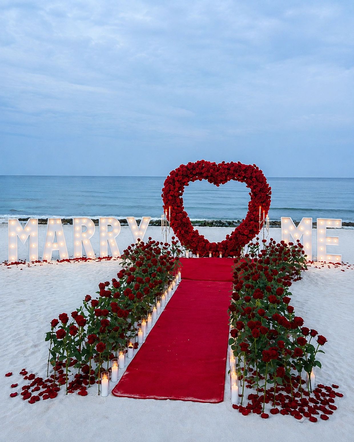Romantic beach proposal setup with roses and lights.
