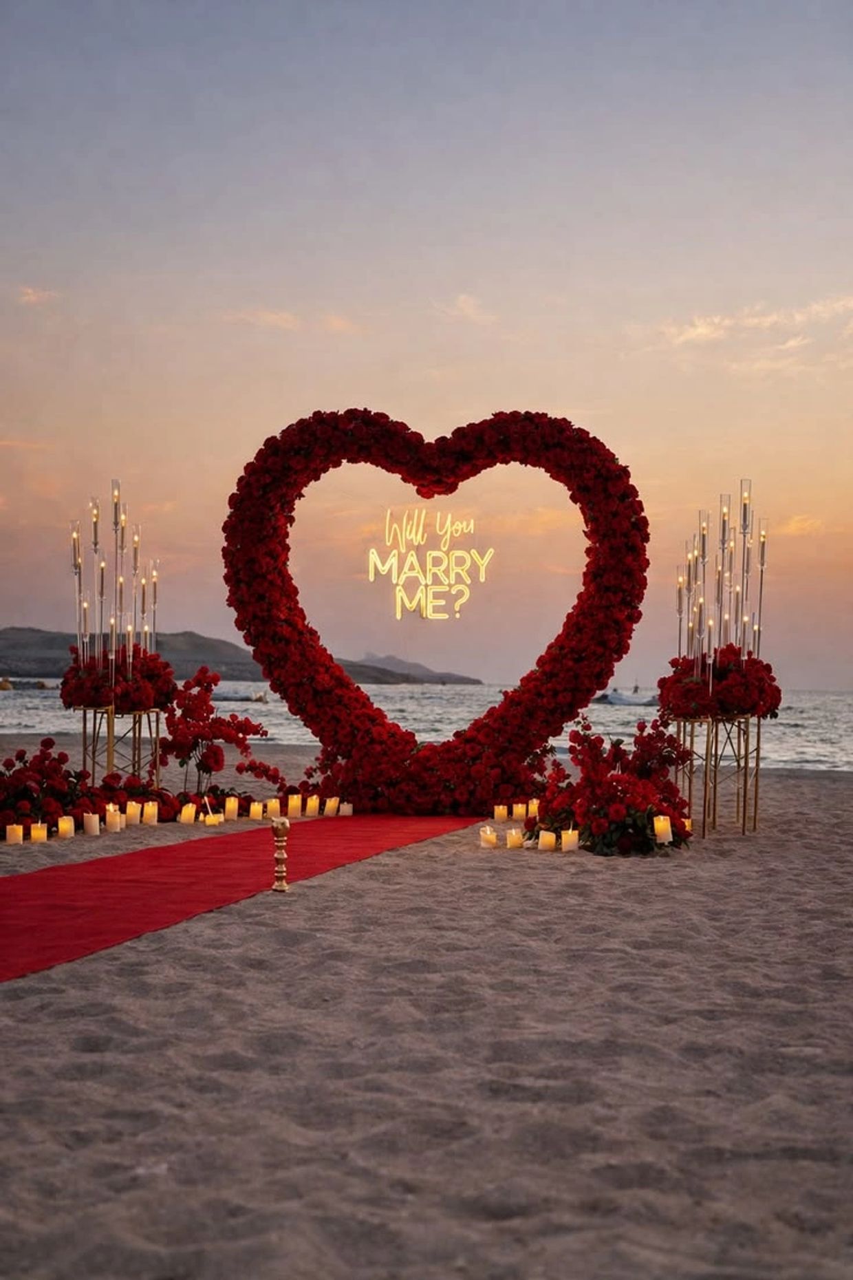 Romantic beach proposal setup with a heart-shaped rose arch and candles at sunset.